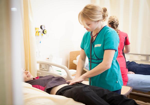 A BSN Student examining a patient in VIU's BC Nursing Program