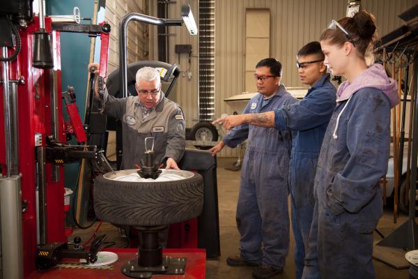 An instructor of the Automotive Service Technician program explaining a tool to students