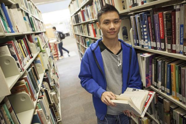 A Degree in Criminology student reading a book in the library