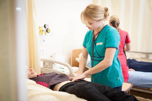 A BSN Student examining a patient in VIU's BC Nursing Program