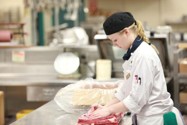 A female student of the Culinary Arts Bridging to Bachelor of Hospitality Management program in the kitchen