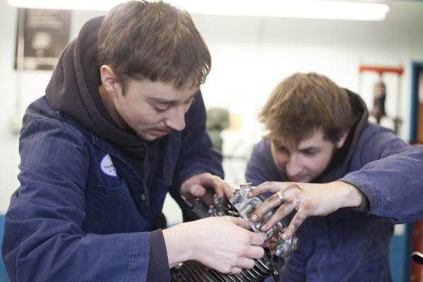 Students of the Marine Technician and Motorcycle Mechanic program repairing an engine