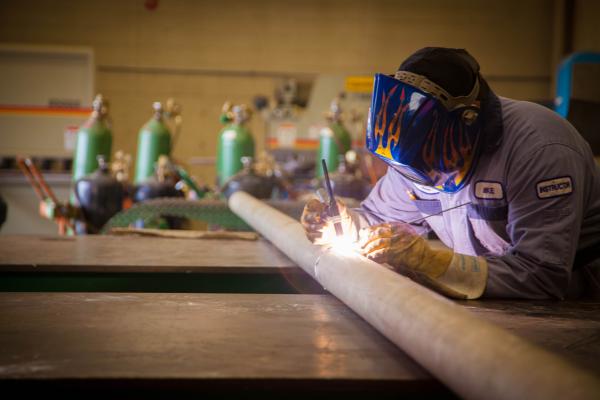 A VIU's Welding certificate student is welding a pipe