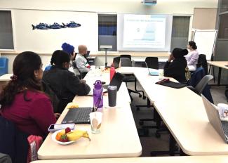Group of people watching a presentation and eating.