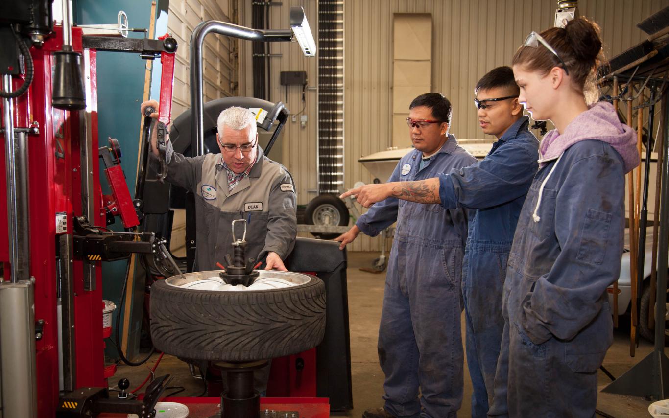 An instructor of the Automotive Service Technician program explaining a tool to students