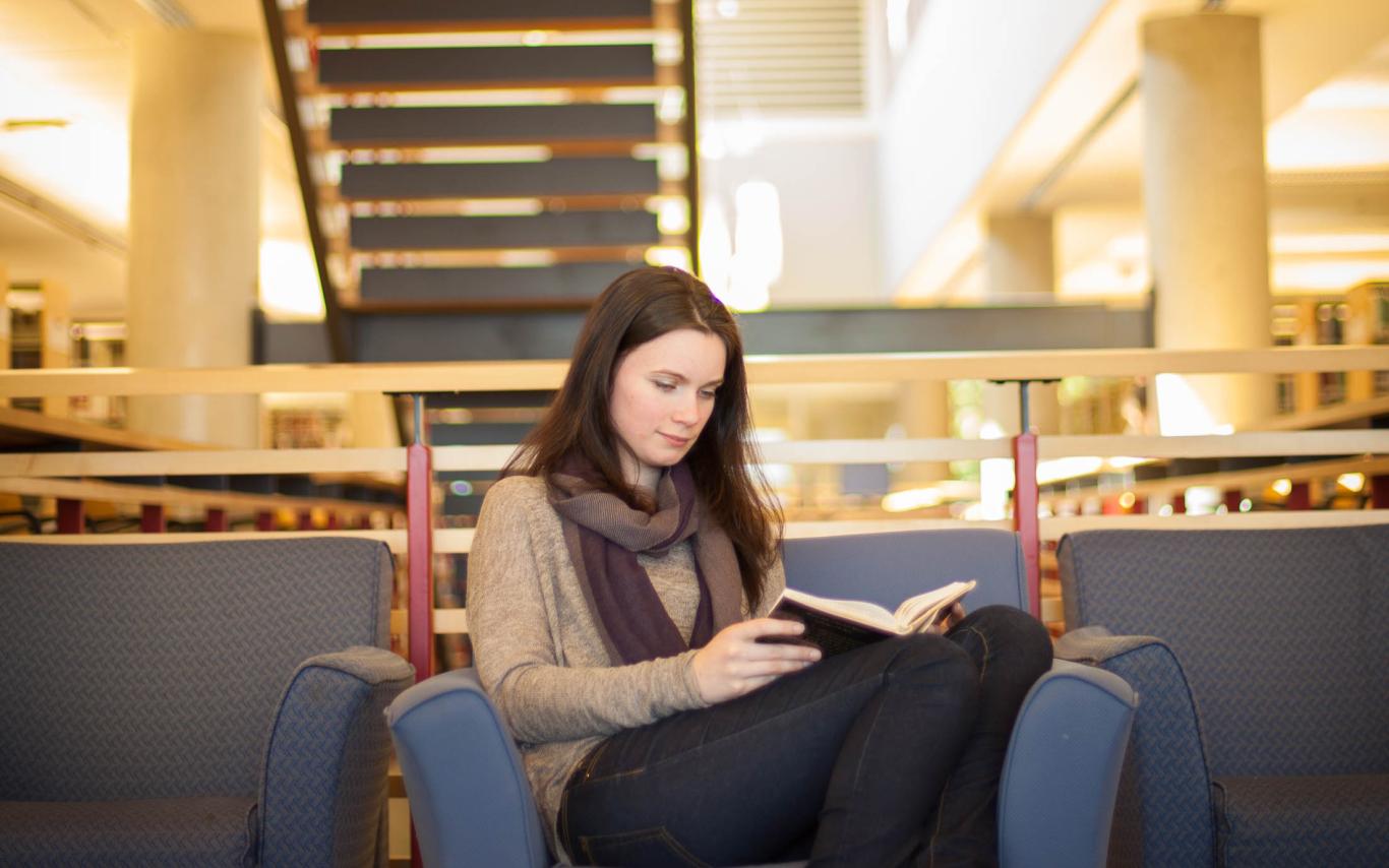 A Bachelor of Arts in English Honours, Major, Minor student studying for her writing courses in the library