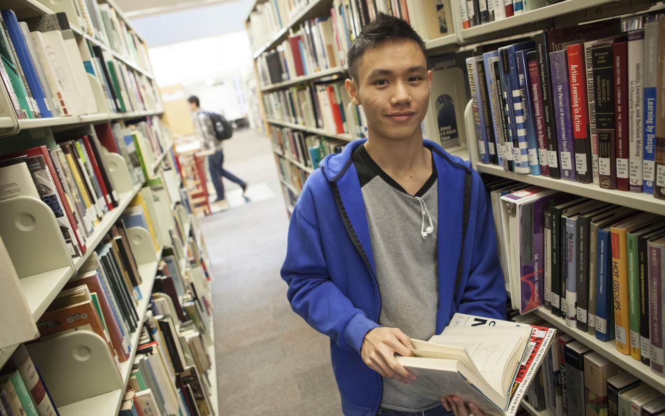 A Degree in Criminology student reading a book in the library