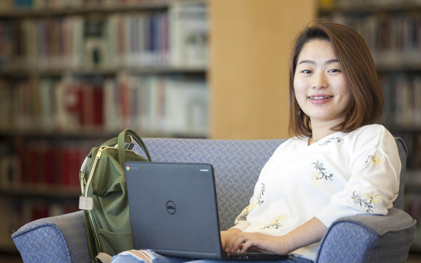 A Student of the Bachelor of Arts, Minor in Digital Media program studying in the library