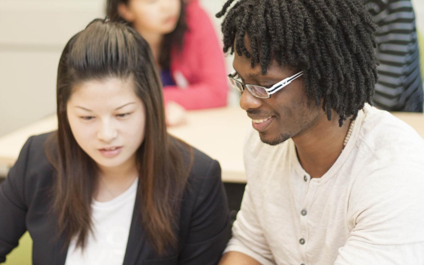 A male student of the Bachelor of Arts, Minor in Media Studies program talking to a fellow student