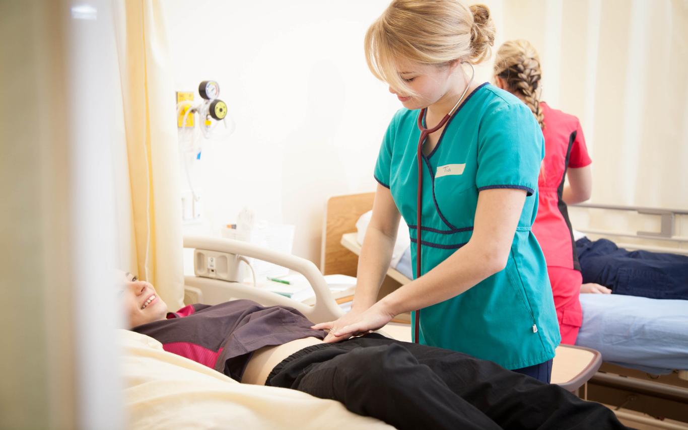 A BSN Student examining a patient in VIU's BC Nursing Program