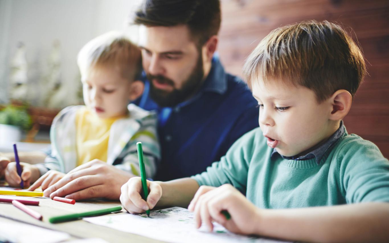 An early Childhood Education worker is taking care of two boys