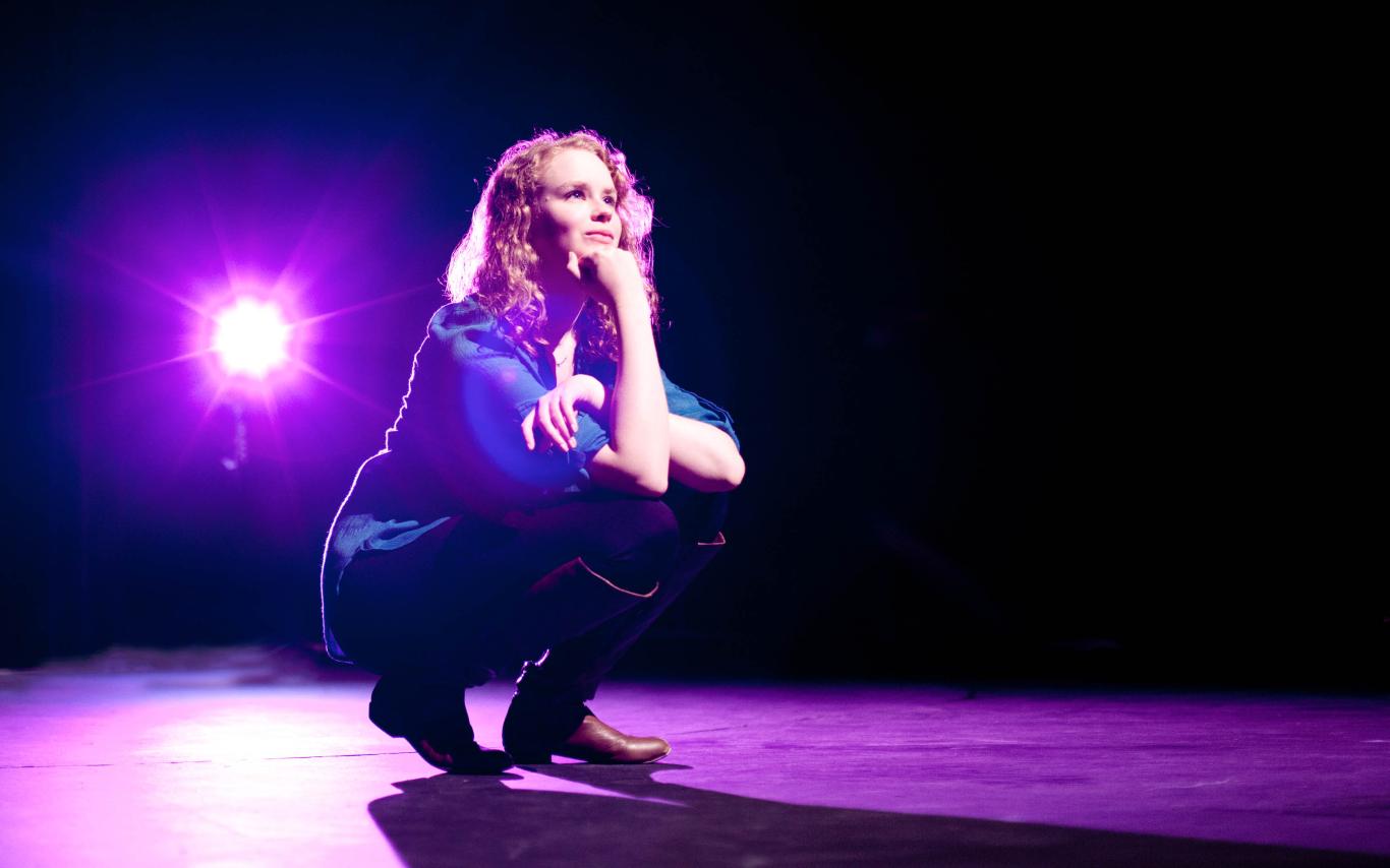 A female student of the Theatre program on stage