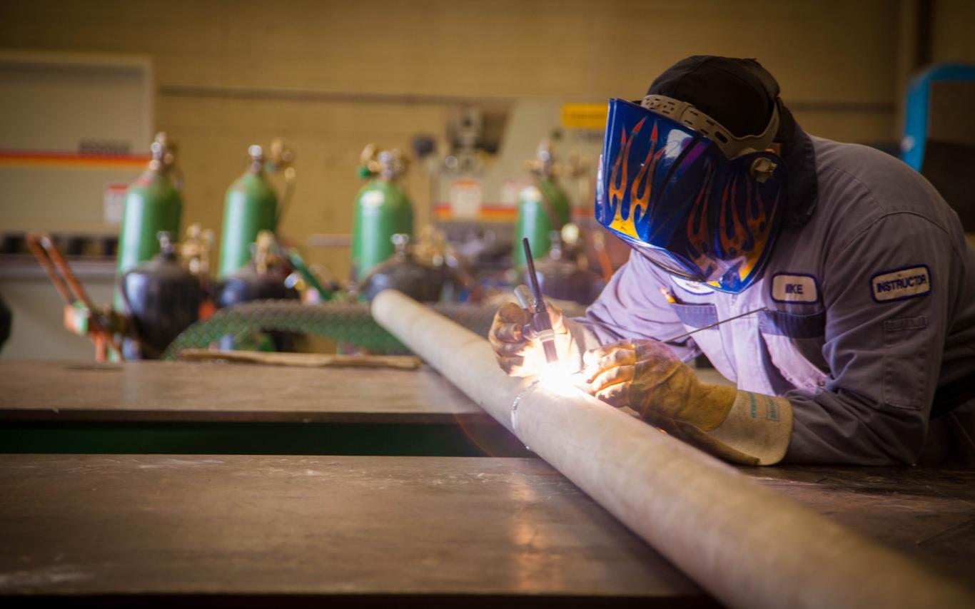 A VIU's Welding certificate student is welding a pipe