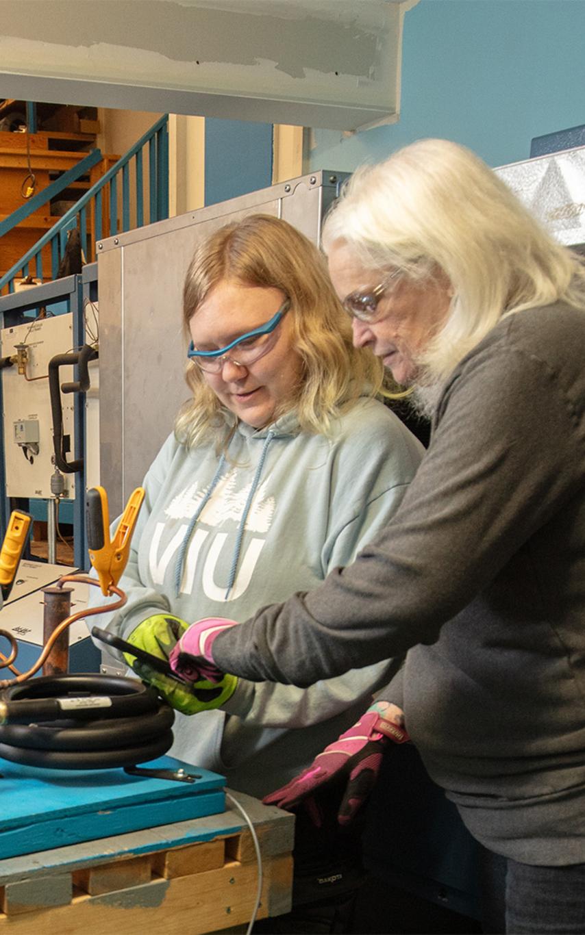 A VIU student and instructor look at mechanical elements together..