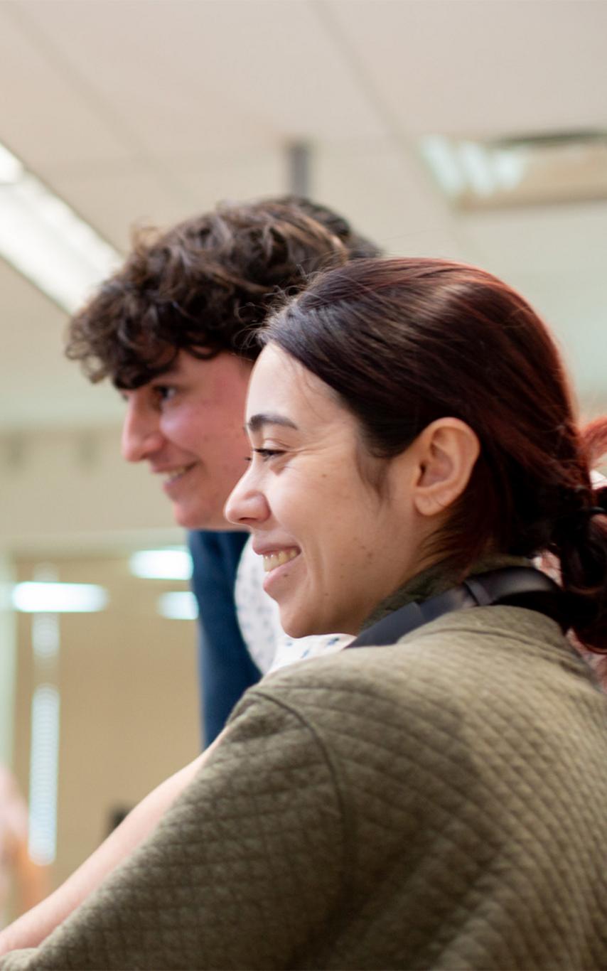Two young people working at a computer station. 