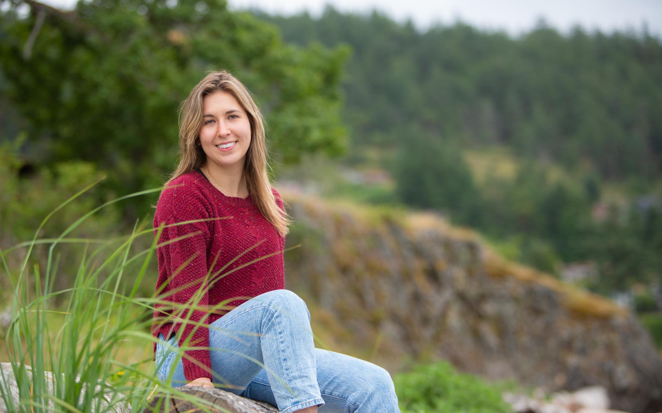 Portrait of Marissa sitting on grass smiling at camera