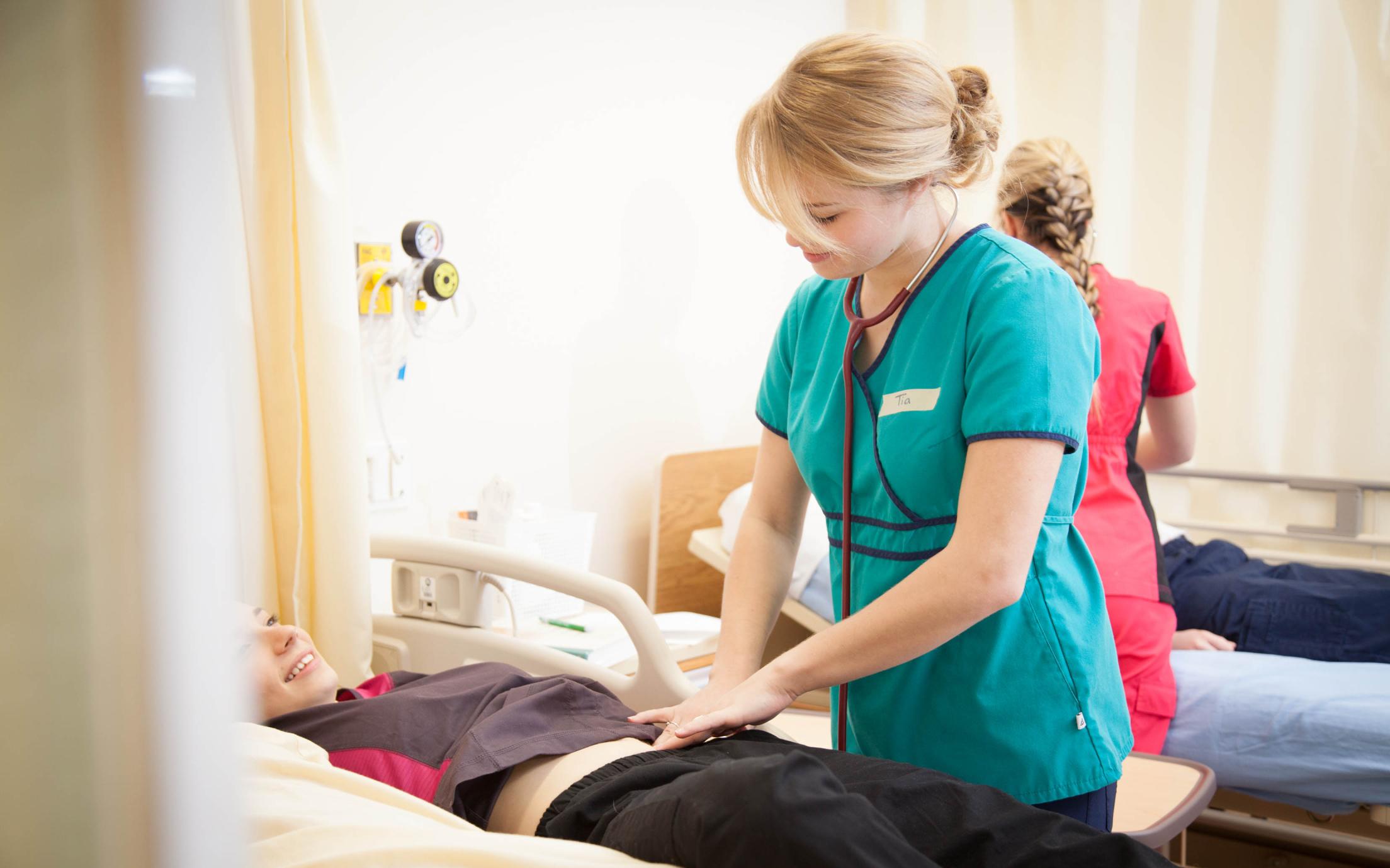 A BSN Student examining a patient in VIU's BC Nursing Program