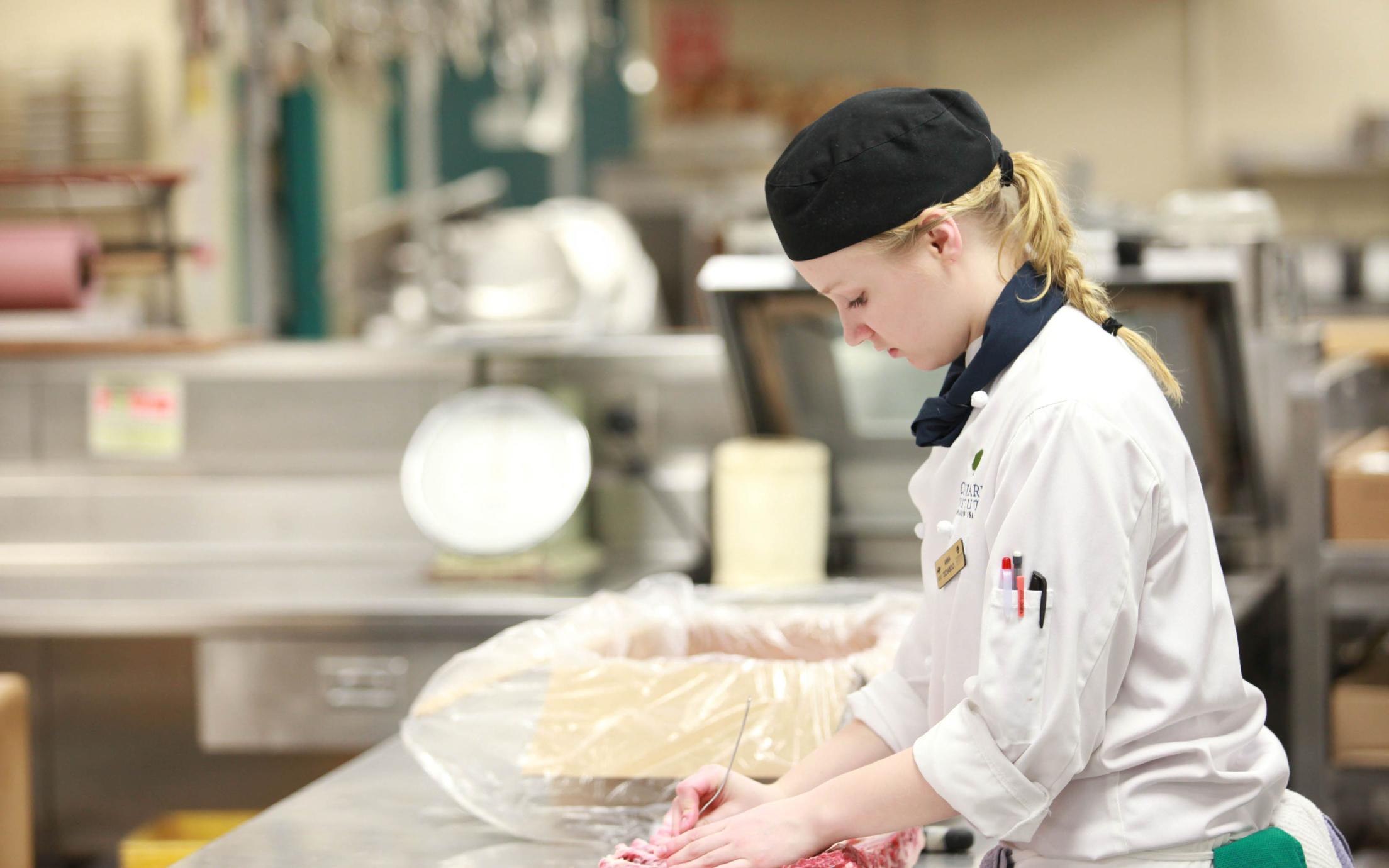 A female student of the Culinary Arts Bridging to Bachelor of Hospitality Management program in the kitchen
