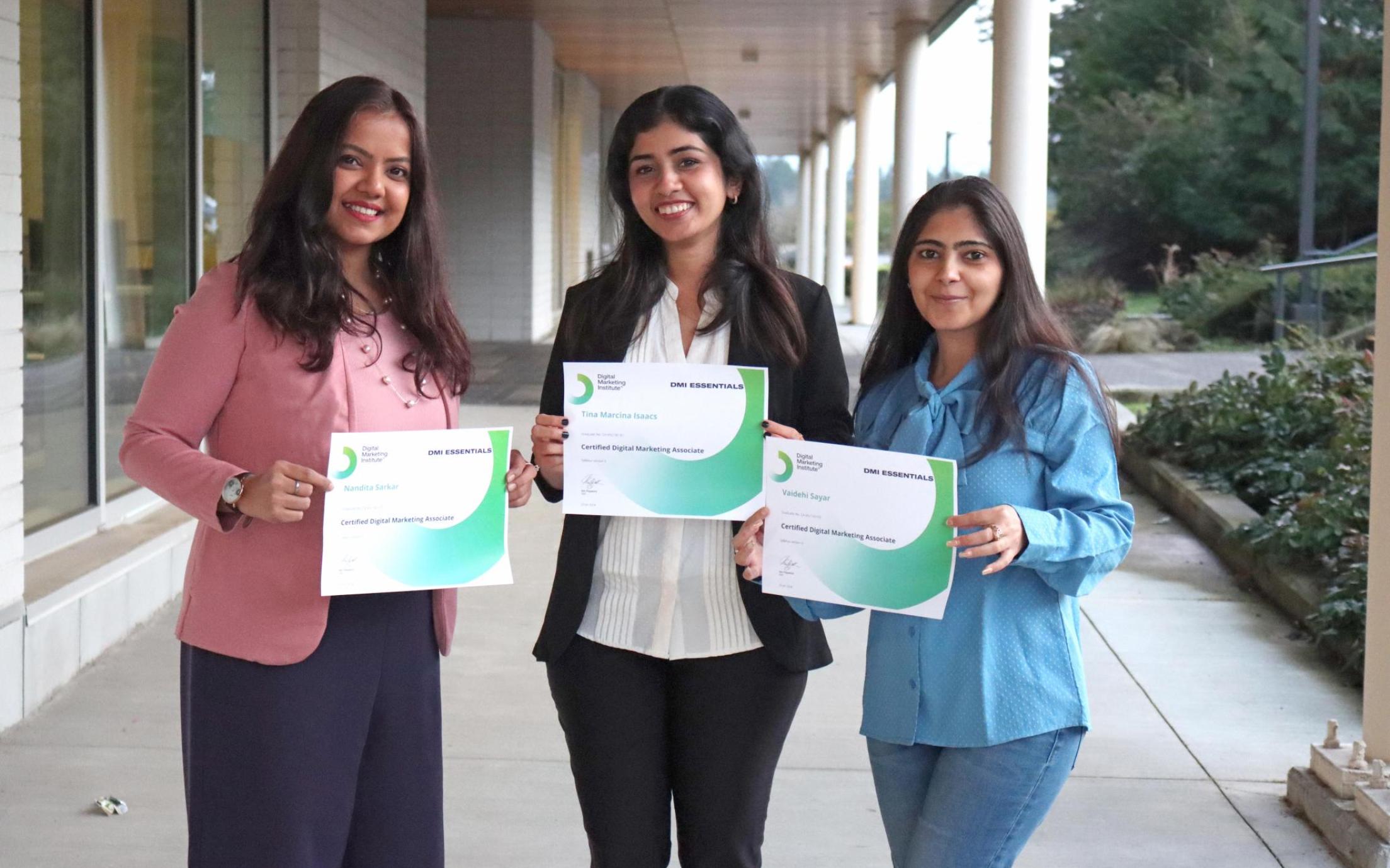 Three women hold certificates