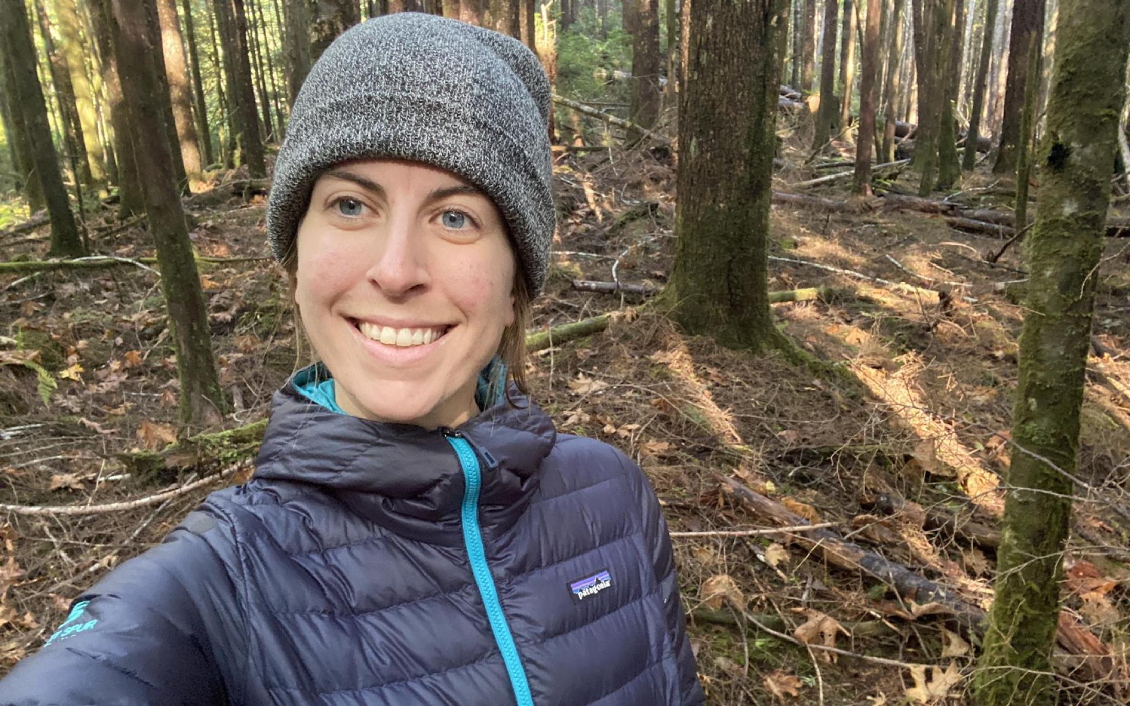 Nadia Linning standing in the woods and smiling at the camera