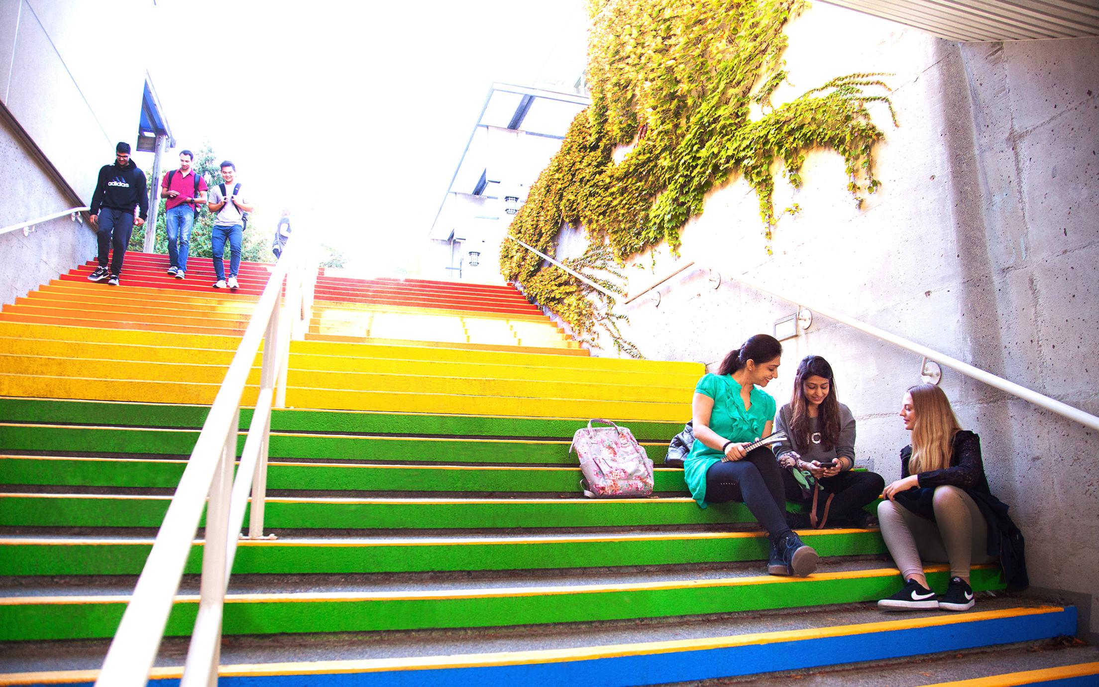 People sitting on rainbow stairs at VIU's Nanaimo campus