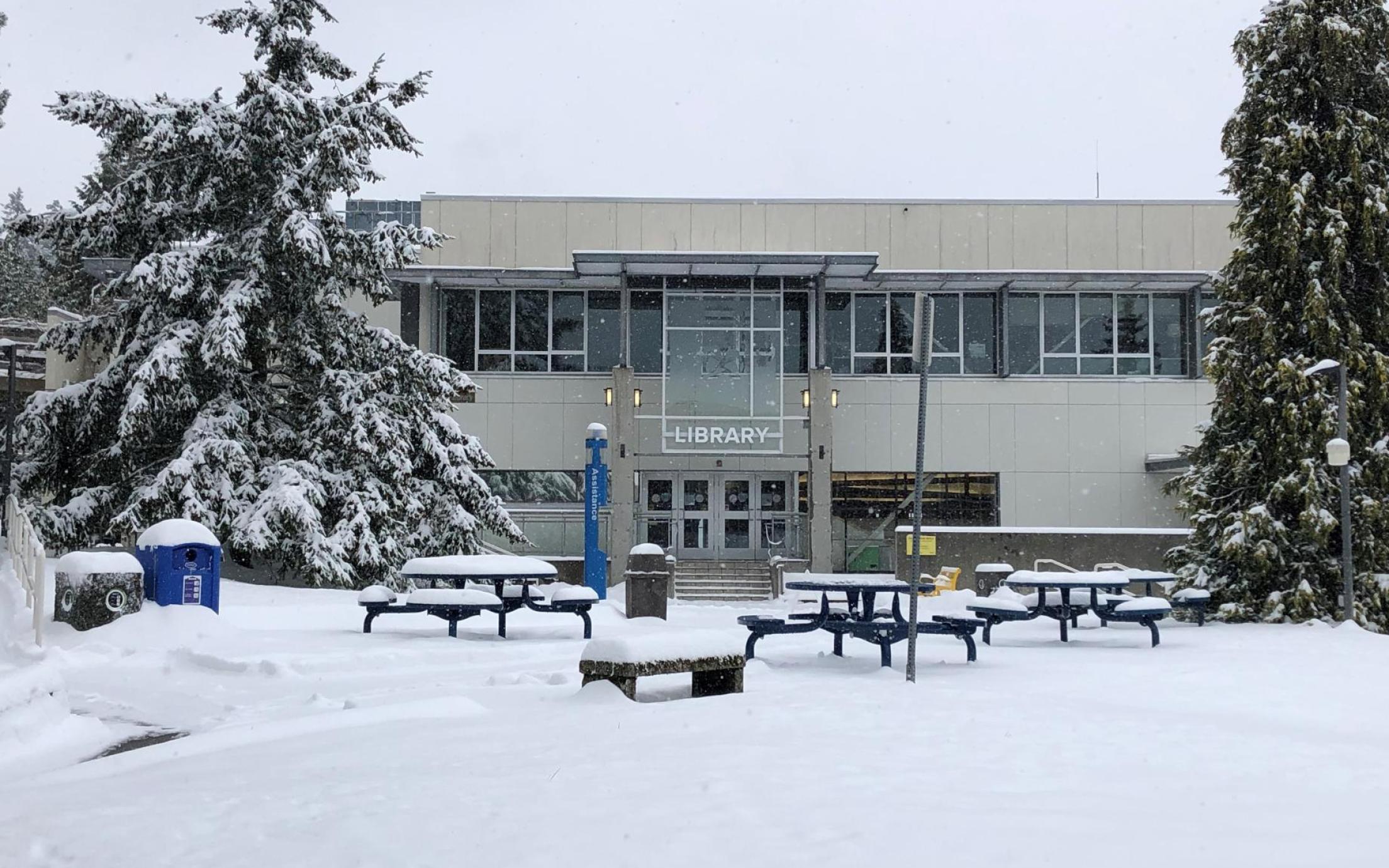 A view of VIU's Nanaimo campus library from the exterior with a snowed-in quad