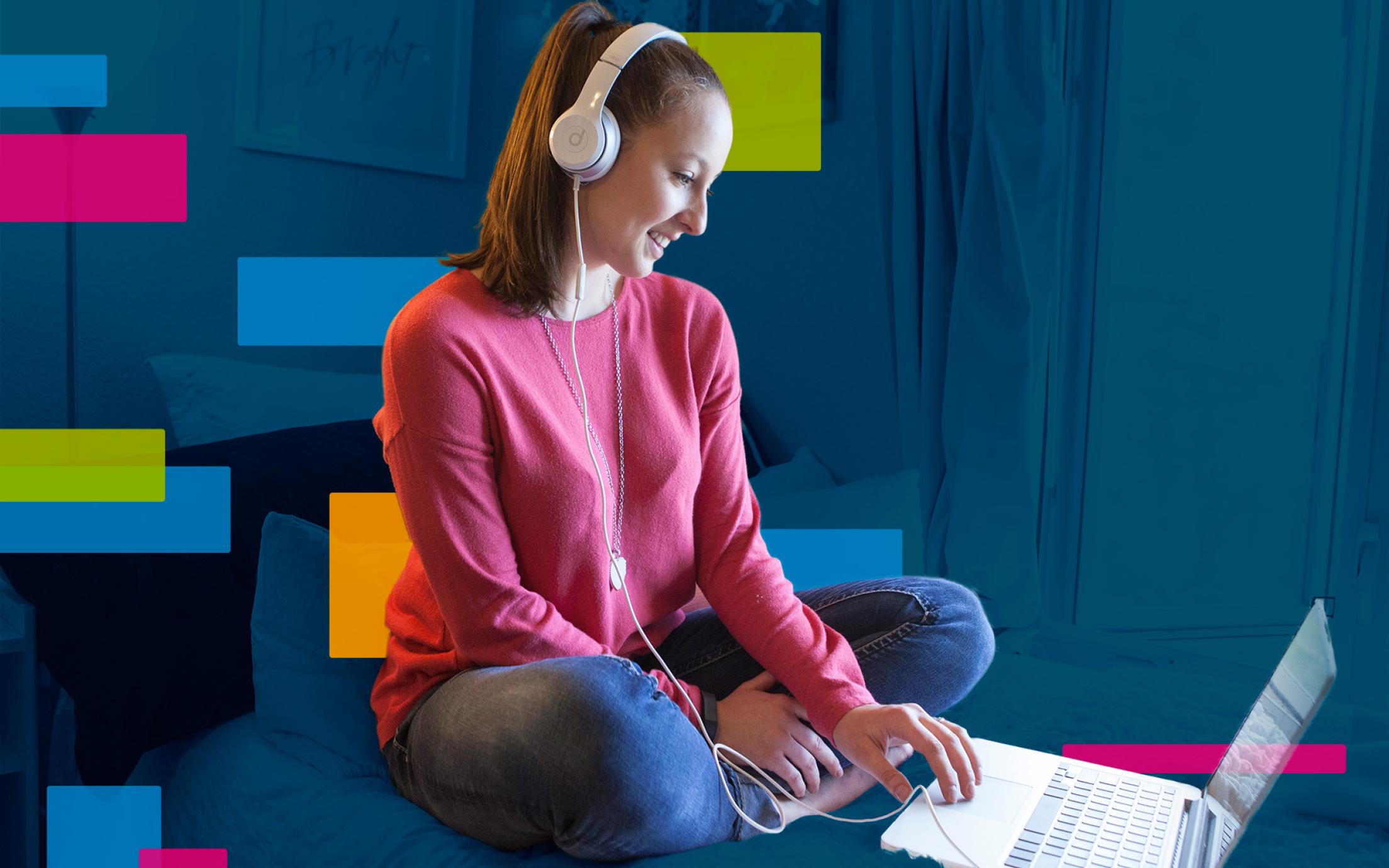 Girl with headphones on looking at a computer