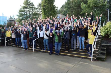 Group photo of people raising their hands in celebration