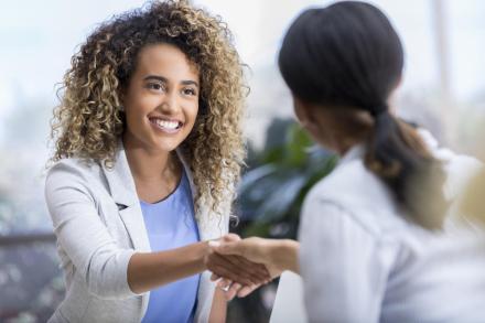a woman shakes hands with another woman