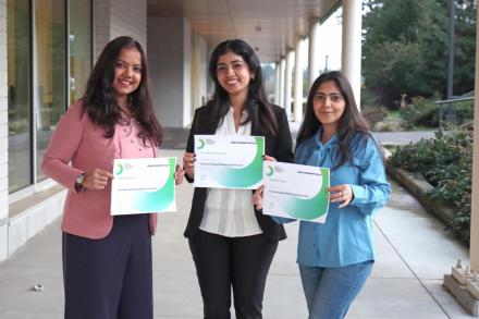 Three women hold certificates