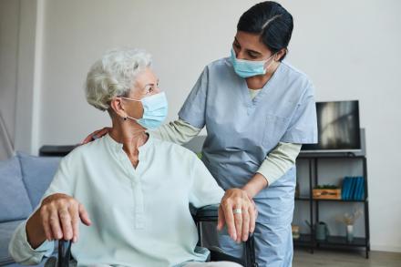 A health-care worker helps a patient