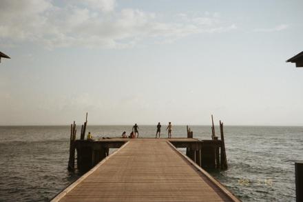 A dock with people on it, ocean behind