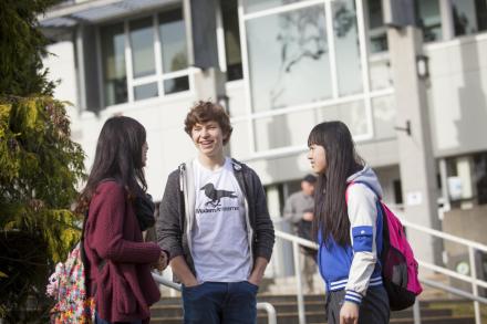 Three students talking to each other in front of VIU library