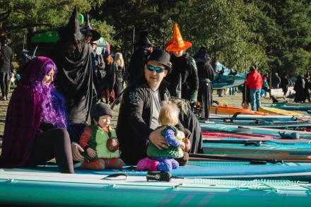 People dressed in costumes sitting on paddleboards at Westwood Lake