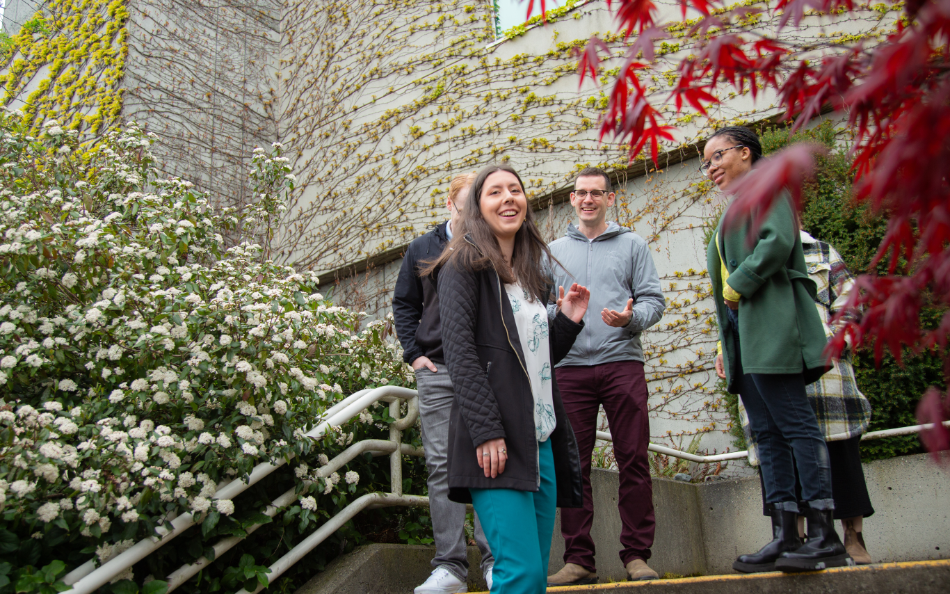 A group of young people chatting in a landscaped setting. 