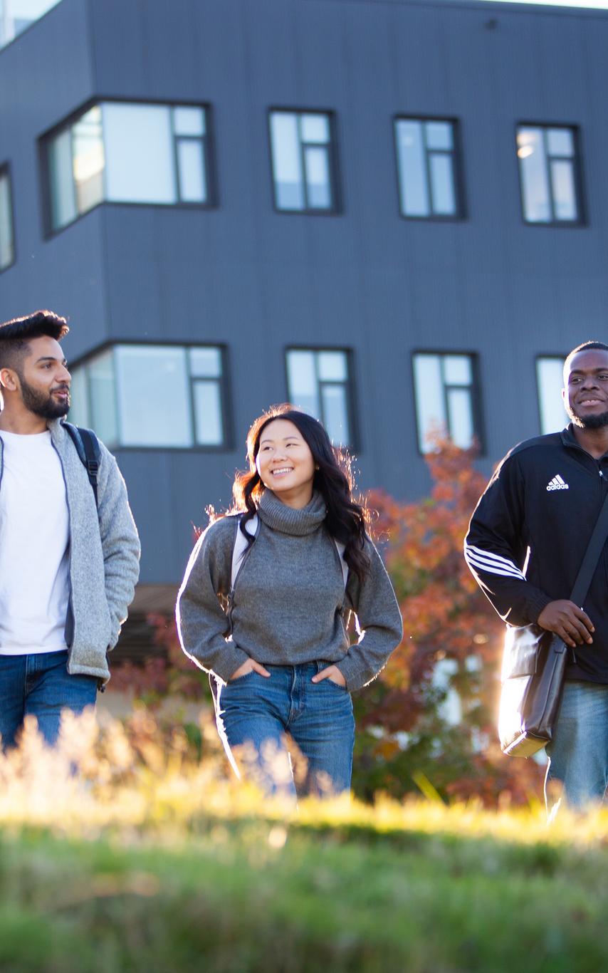 Three young people walking outside a modern-looking building