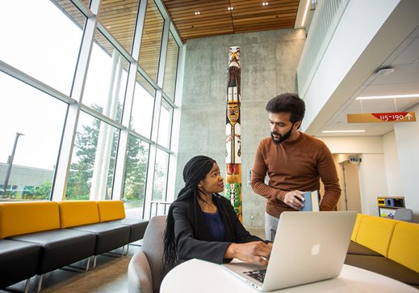 Two people working at a laptop together