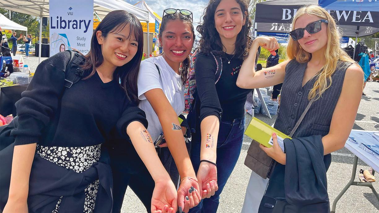 Group of girls showing off temporary VIU tattoos on their forearms